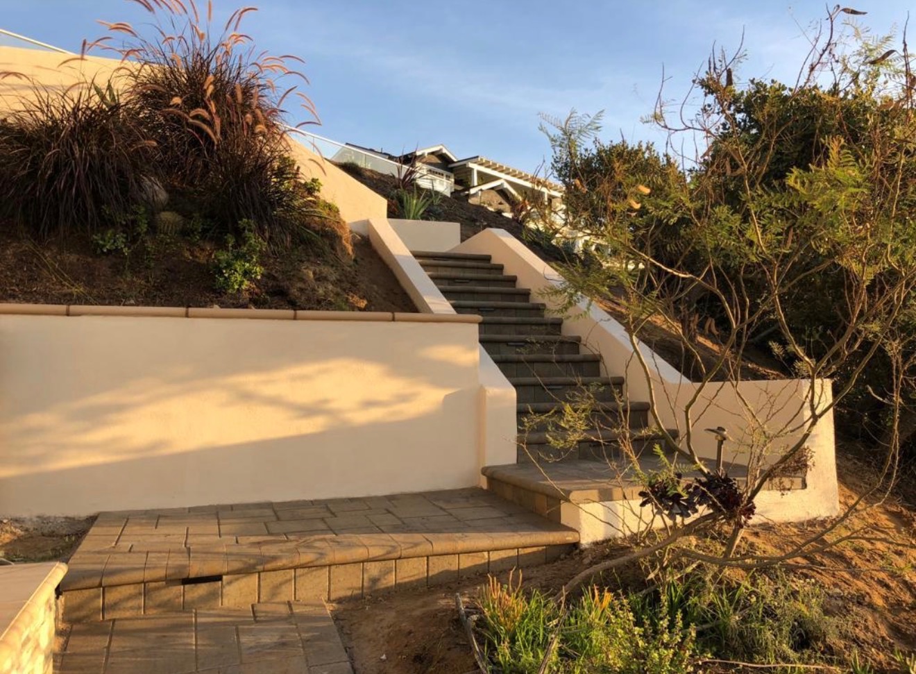 Hillside staircase after — finished stone pavers and stucco walls