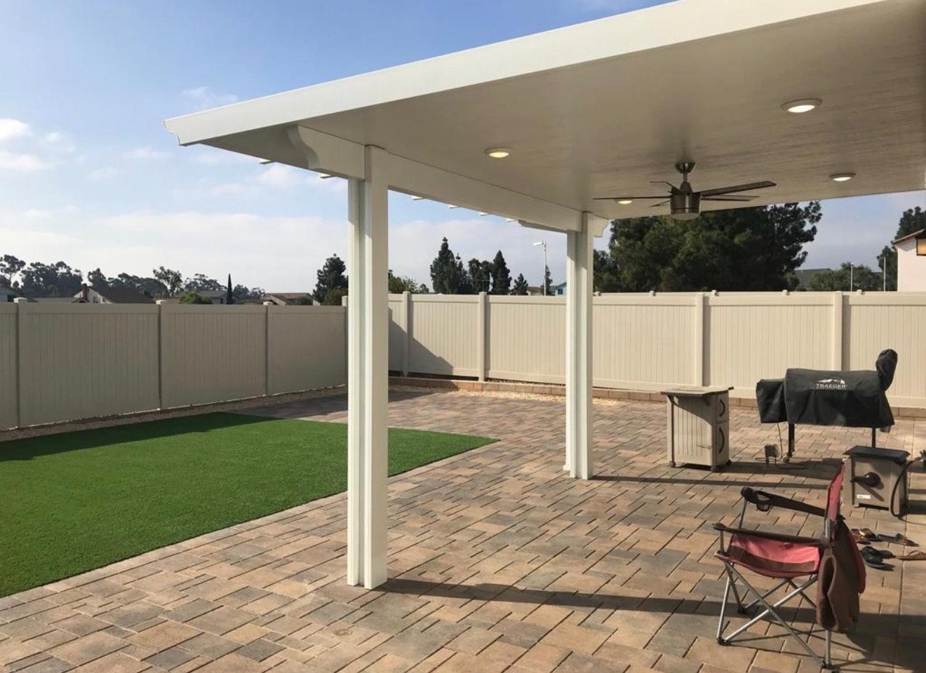 Backyard alumawood patio cover with ceiling fan and paver patio